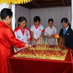 Gia đình Việt đang thắp nhang tại bàn thờ gia tiên